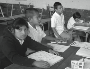 Niños y niña en pupitres.png